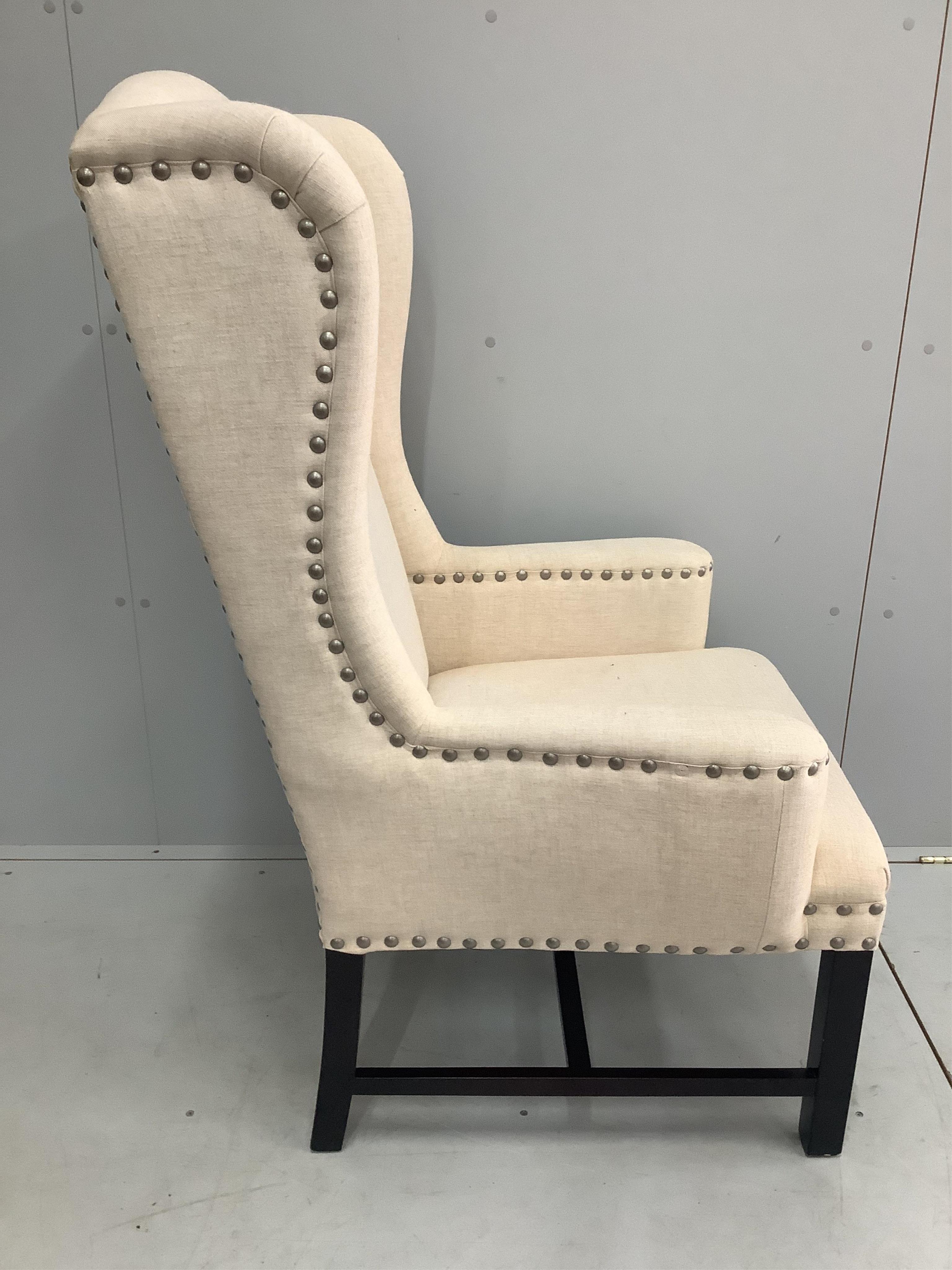 A cream canvas OKA wingback chair, width 72cm, depth 68cm, height 120cm. Condition - good